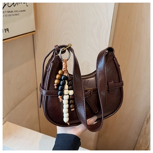 Detail of brown faux leather crescent bag with decorative tricolor wooden beads