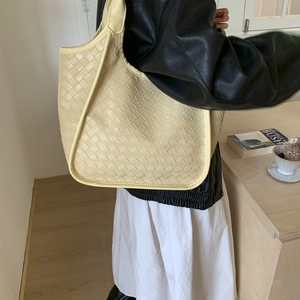 Detail of light yellow woven leather hobo bag showing large capacity and craftsmanship