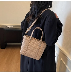 Detail of light brown woven leather texture on a bucket bag with silver hardware