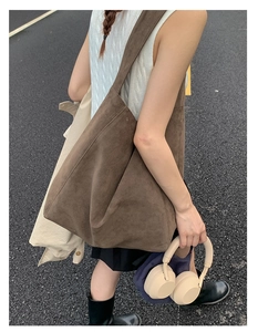 Outdoor shot of a large brown suede tote bag with wide straps in a vintage casual style