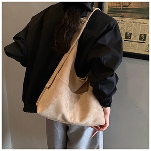 Vista laterale della grande borsa tote in pelle scamosciata kaki indossata da modella