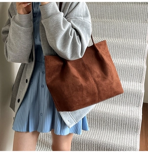 Detailed view of the brown suede tote bag featuring a vertical central seam design