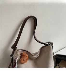 Detailansicht beige Tragetasche mit braunen Trägern und süßem Bärenanhänger-Dekor