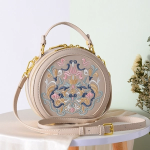 Detail of colorful floral embroidery on a round beige Chinese style crossbody bag