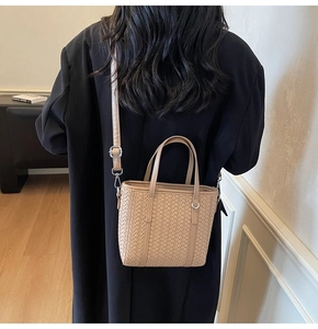 Close-up of woven shoulder bag with adjustable strap and silver metal buckle