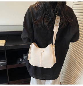Detail of cream bucket bag with wide ethnic pattern strap and textured PU leather