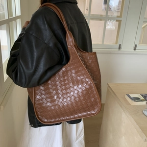 Detail showing the woven leather texture and spacious hobo style of the brown shoulder bag