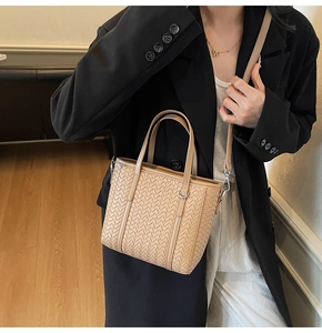 Detail of light khaki woven texture handbag with dual handles and crossbody strap