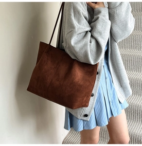 Brown suede tote bag styled on shoulder, showing large capacity and minimalist design