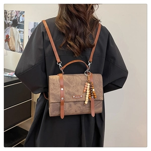Vue détaillée du sac à dos vintage en similicuir marron avec perles en bois et logo
