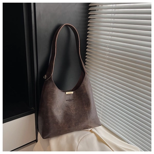 Detail of vintage dark brown faux leather bucket bag featuring YUNDON embossed lettering