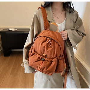 Lightweight burnt orange nylon backpack with drawstring pleated pocket and large main compartment
