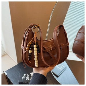 Detailed macro view of dark brown faux leather hobo bag with vintage wooden beads