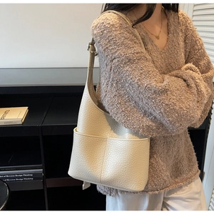 Detail of off-white lychee leather shoulder bag with two front pockets and silver buckle