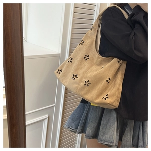 Détail de fleurs découpées au laser sur un sac cabas en daim marron pour le quotidien