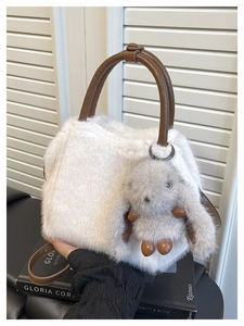 Weiße Webpelz-Handtasche mit dunkelbraunen Ledergriffen und grauem Hasenanhänger