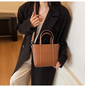 Close-up of brown woven texture on bucket bag with detachable leather shoulder strap
