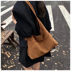 Borsa hobo in camoscio marrone con dettaglio su trama del materiale e cuciture