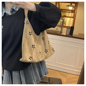 Détail du sac fourre-tout en daim kaki avec motifs floraux découpés au laser