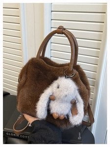 Nahaufnahme der flauschigen dunkelbraunen Kunstpelztasche mit süßem weißen Hasenanhänger