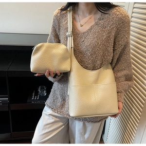 Detail shot of beige hobo bag set featuring pebbled faux leather and matching pouch
