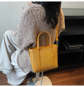 Detailed macro of vibrant yellow woven texture and sturdy handle on the tote bag