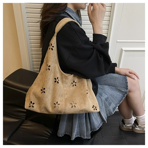 Détail du sac cabas en daim camel avec motifs floraux découpés au laser et bandoulière souple