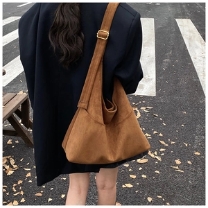Dettaglio della borsa tote in pelle scamosciata marrone con tracolla e fibbia d'oro