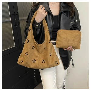 Détail du sac cabas marron en daim avec motifs floraux découpés au laser et pochette