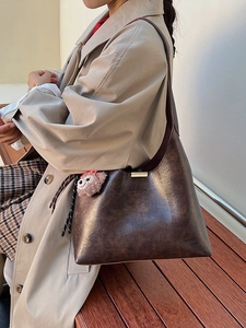 Vintage dark brown textured leather tote bag with gold metal clasp and plush charm