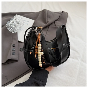 Detail of black crescent hobo bag with vintage wooden beads and faux leather finish