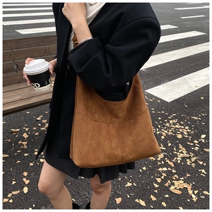 Dettaglio della borsa hobo in pelle scamosciata marrone con tracolla larga in esterna