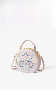 Detail of New Chinese Style round bag with floral embroidery and gold zipper hardware