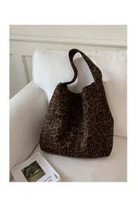 Close-up of leopard print fabric tote bag on a white sofa with fashion magazine