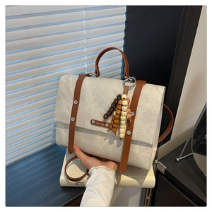 Détail du sac à dos rétro avec garniture en cuir et breloque en perles de bois