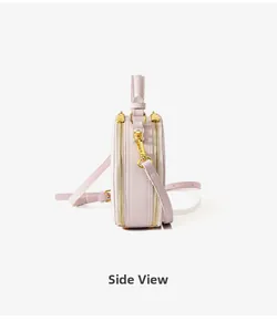 Side view of lavender round crossbody bag with dual golden zippers and textured leather