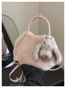 Detail der rosa Kunstfell-Handtasche mit süßem Hasen-Anhänger und Ledergriff zum Tragen