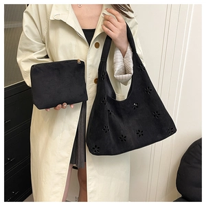 Détail du sac cabas noir givré avec motifs floraux découpés et pochette assortie