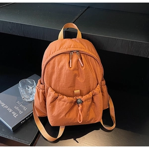 Detail of caramel nylon backpack with drawstring pocket and sturdy shoulder straps