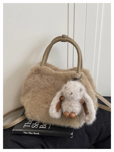 Detail der flauschigen Plüschtasche mit Ledergriffen und niedlichem Kaninchen-Anhänger