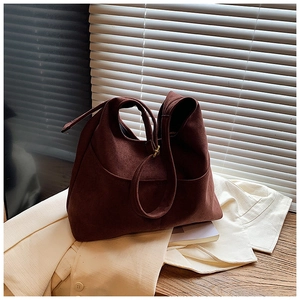 Dettaglio della borsa tote in pelle scamosciata marrone scuro dal design minimalista