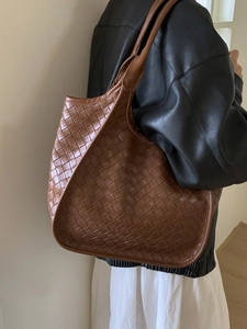Brown woven leather tote bag for women showing large capacity shoulder style on model