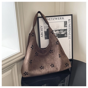 Détail du sac Hobo en daim marron avec découpes florales et grande capacité de rangement