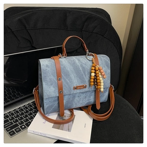 Détail du sac à dos rétro bleu clair avec sangles brunes et pendentif en perles