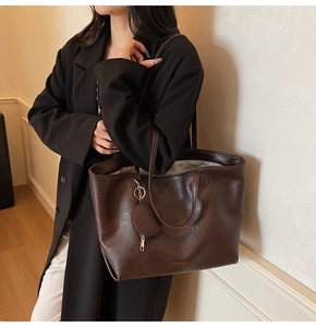 Deep brown large capacity tote bag with matching coin pouch on a female model