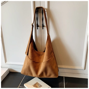 Dettaglio della borsa tote in pelle scamosciata marrone con tasche laterali e fibbia