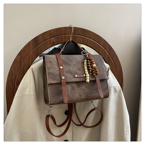 Vue détaillée d'un sac à dos vintage marron avec sangles en cuir et pendentif