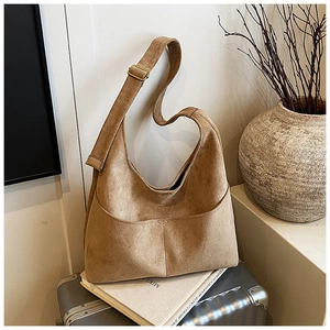 Dettaglio della borsa tote in pelle scamosciata con tracolla e fibbie dorate