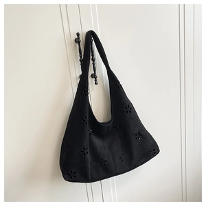 Détail du motif floral découpé au laser sur le sac cabas noir en daim dépoli style hobo