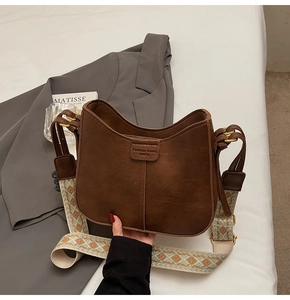 Détail du sac seau marron rétro avec bandoulière large à motifs géométriques